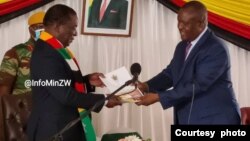 UMnangagwa unika induna Fortune Charumbira ugwalo olujulileyo olumayelana lombhuqazwe weGukurahundi. (Photo: Ministry of Information)