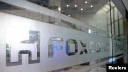 FILE - A sign of Foxconn is seen at a glass door inside its office building in Taipei, Taiwan Nov. 12, 2020.