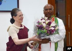 This photograph provided by India’s main opposition Congress Party shows the party’s interim president Sonia Gandhi, left, greeting their newly elected president Mallikarjun Kharge in New Delhi, India, Oct.19, 2022.