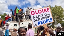 Des manifestants se tiennent au sommet d'un véhicule blindé des Nations Unies lors d'une manifestation à Ouagadougou, le 2 octobre 2022.