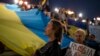 Ukrainian people who live in Greece hold a Ukrainian flag as they protest in central Athens, to condemn the Russian strikes against multiple cities across Ukraine and to mark Ukraine's Defenders Day, on Oct. 14, 2022.