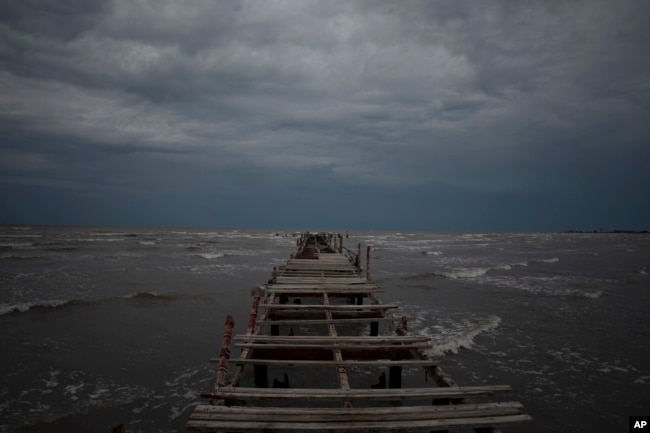 Waves kick up under a dark sky along the shore of Batabano, Cuba, Monday, Sept. 26, 2022. Hurricane Ian was growing stronger as it approached the western tip of Cuba on a track to hit the west coast of Florida as a major hurricane as early as Wednesday. (AP Photo/Ramon Espinosa)