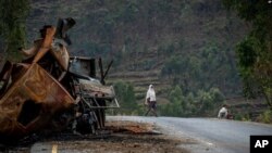 Seorang pria berjalan melintas di dekat sebuah truk yang hancur di wilayah Tigray, Ethiopia, pada 11 Mei 2021. (Foto: AP)