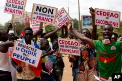 FILE - Supporters of Capt. Ibrahim Traore protest against France and the West African regional bloc known as ECOWAS in the streets of Ouagadougou, Burkina Faso, Oct. 4, 2022.