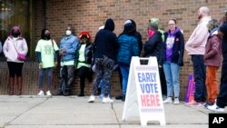 People line up outside a polling station to cast their votes in Milwaukee, Wisconsin, Oct. 25, 2022.