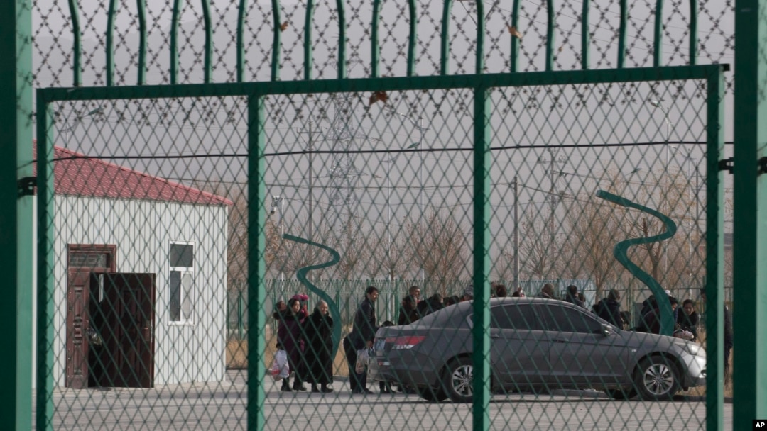 FILE - Residents line up inside the Artux City Vocational Skills Education Training Service Center, which was revealed by leaked documents to be a forced indoctrination camp at the Kunshan Industrial Park in Artux in western China's Xinjiang region, Dec. 3, 2018.