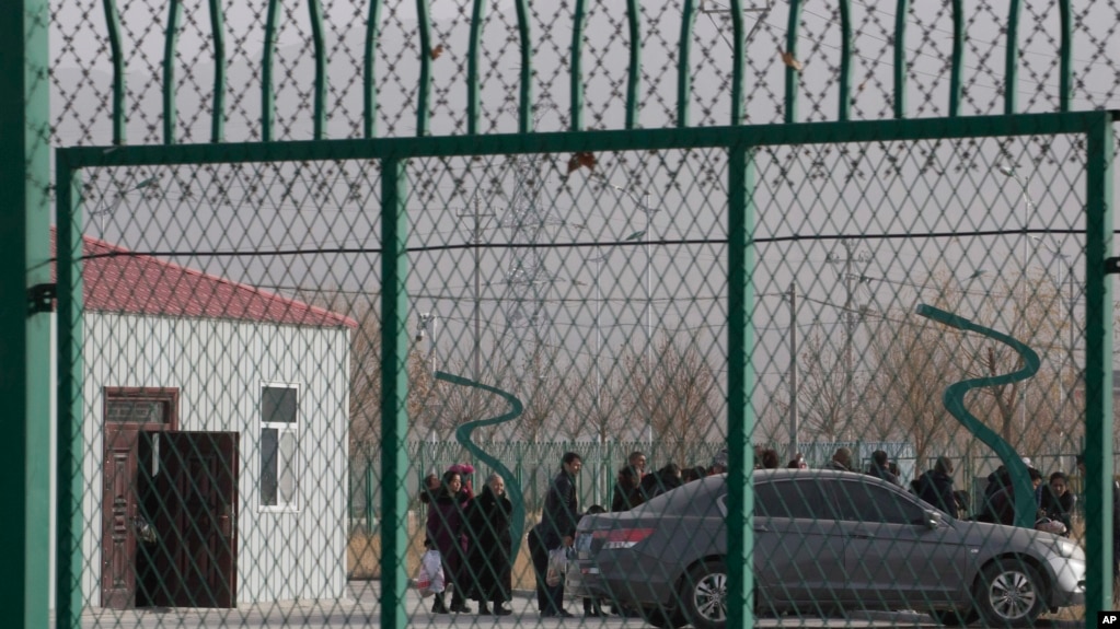 FILE - Residents line up inside the Artux City Vocational Skills Education Training Service Center, which was revealed by leaked documents to be a forced indoctrination camp at the Kunshan Industrial Park in Artux in western China's Xinjiang region, Dec. 3, 2018.