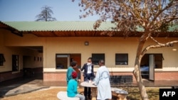 FILE - TB patients do painting activities with a caretaker in the garden of Ward 16, where the drug-resistant tuberculosis patients are housed and treated, on August 5, 2019, at the Sizwe Tropical Diseases Hospital in Johannesburg, South Africa,