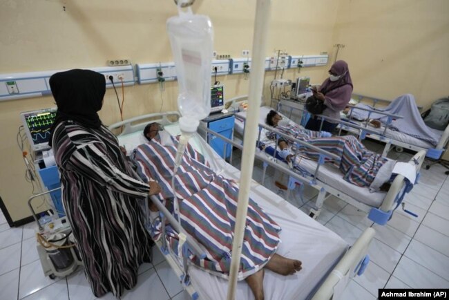 Relatives stand nearby as survivors of Saturday's deadly crush are treated at a hospital in Malang, East Java, Indonesia, on October 3, 2022. (AP Photo/Achmad Ibrahim)