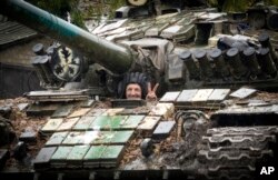 Tentara Ukraina membentuk tanda kemenangan dengan dua jarinya di Bakhmut, tempat pertempuran terberat melawan pasukan Rusia di wilayah Donetsk, Ukraina, Rabu, 26 Oktober 2022. (AP/Efrem Lukatsky)