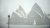 A yacht sails next to the Opera House while it rains in Sydney on Oct. 6, 2022. 