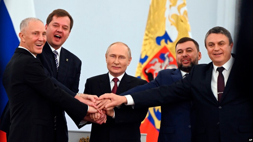 2022年9月30日俄罗斯总统普京在克里姆林宫签署条约，正式启动吞并被俄军部分占领的乌克兰四州领土的程序。从左至右：莫斯科任命的赫尔松地区领导人弗拉基米尔·萨尔多(Vladimir Saldo)、莫斯科任命的扎波罗热地区领导人叶夫根尼·巴利茨基(Yevgeny Balitsky)、普京(中)、自我委任的顿涅茨克人民共和国领导人丹尼斯·普希林(Denis Pushilin)以及自我委任的卢甘斯克人民共和国领导人列昂尼德·帕什尼克(Leonid Pasechnik)。-美联社照片