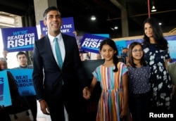 FILE - Then-Conservative leadership candidate Rishi Sunak, his wife Akshata Murthy and his daughters Anoushka and Krishna attend a Conservative Party leadership campaign event in Grantham, Britain, July 23, 2022.