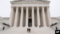 Justice Ketanji Brown Jackson is escorted by Chief Justice of the United States John Roberts following her formal investiture ceremony at the Supreme Court in Washington, Sept. 30, 2022.