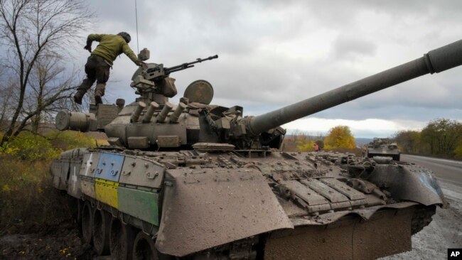 Ukrainian soldiers work with a captured Russian T-80 tank on a road near Bakhmut, in Ukraine's Donetsk region, Oct. 27, 2022.