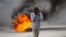 FILE - A man walks past a burning barricade during a protest over the death of journalist Romelo Vilsaint, in Port-au-Prince, Haiti, Oct. 30, 2022. As violence sweeps Haiti, the country's journalists are being targeted. 