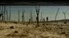 FILE - People walk close to the border at Yesa's reservoir affected by drought, in Yesa, northern Spain, Sept. 14, 2022. 