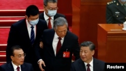 2022年10月22日，在北京人民大会堂举行的中共二十大闭幕式上，前中共总书记胡锦涛被警卫扶着离席。