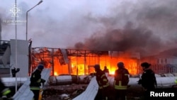 Firefighters work at the site of a car retailer office building, destroyed during a Russian missile attack in Zaporizhzhia, Ukraine Oct. 11, 2022. (Handout photo/Press service of the State Emergency Service of Ukraine)