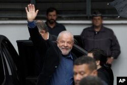 Former Brazilian President Luiz Inacio Lula da Silva waves upon his arrival to a polling station to vote in the general election in Sao Paulo, Brazil, Sunday, Oct. 2, 2022. (AP Photo/Marcelo Chello)