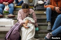 A woman with a cat shelters inside a subway station during a Russian missile attack in Kyiv, Ukraine, Oct. 11, 2022. (REUTERS/Viacheslav Ratynskyi)