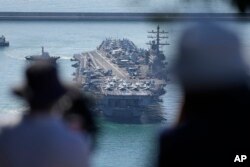 The nuclear-powered aircraft carrier USS Ronald Reagan is escorted as it arrives in Busan, South Korea, Sept. 23, 2022.