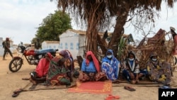 FILE - A group of women take shelter under a tree a the Bogo IDP camp in Maroua, Cameroon, April 28, 2022.