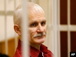 FILE - Ales Bialiatski, the head of Belarusian Vyasna rights group, stands in a defendants' cage during a court session in Minsk, Belarus, on Nov. 2, 2011. On Friday, Oct. 7, 2022 the Nobel Peace Prize was awarded to Bialiatski, the Russian group Memorial and the Ukrainian organization Center for Civil Liberties. (AP Photo/Sergei Grits, File)