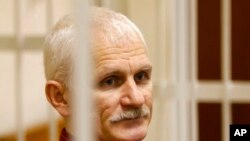 FILE - Ales Bialiatski, the head of Belarusian Vyasna rights group, stands in a defendants' cage during a court session in Minsk, Belarus, on Nov. 2, 2011.