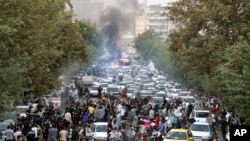  FILE - In this photo taken by an individual not employed by the Associated Press and obtained by the AP outside Iran, protesters chant slogans during a protest over the death of a woman who was detained by the morality police, in downtown Tehran, Iran, Sept. 21, 2022. 