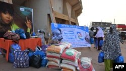 FILE - Residents receive bags of rice, clothes and multiple goods collected by local charity associations for the residents of Djibo, where a supply convoy was attacked the previous week by a an armed group, in Ouagadougou on Oct. 5, 2022.