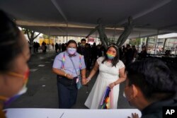 Dayany Marcelo dan istrinya Mayela Villalobos dalam upacara pernikahan massal yang diselenggarakan oleh otoritas kota sebagai bagian dari perayaan bulan kebanggaan LGBT, di Mexico City, Jumat, 24 Juni 2022. (AP/Fernando Llano)