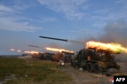 This picture taken on Oct. 6, 2022, and released from North Korea's official Korean Central News Agency (KCNA) on Oct. 10, 2022, shows the North Korean People's Army front-line long-range artillery division and air force squadron during a fire attack training exercise, at an undisclosed location.