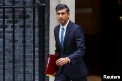 Britain's Prime Minister Rishi Sunak walks outside Number 10 Downing Street, in London, Britain, Oct. 26, 2022.