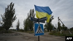 A photograph taken on Sept. 27, 2022, shows a Ukrainian flag waving on a street of the recently liberated village of Vysokopillya, Kherson region, amid the Russian invasion of Ukraine. 