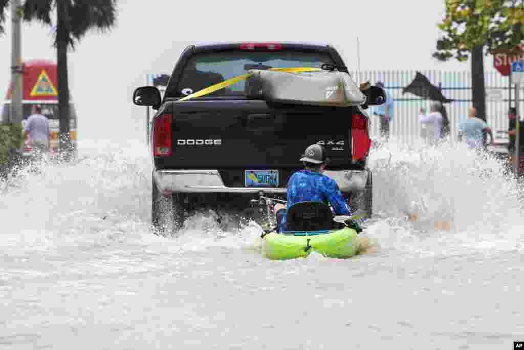 Un camión arrastra a un hombre en un kayak en un camino bajo después de una inundación tras el paso del huracán Ian, en Key West, Florida, el miércoles 28 de septiembre de 2022 por la tarde.