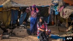 Des femmes travaillent sous des tentes près du village d'Amellagou, dernier rempart des nomades du Maroc, le 2 septembre 2022.