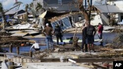 2일 미국 플로리다주 도서지역 주민들이 허리케인 '이언'의 영향으로 파괴된 교량 잔해를 바라보고 있다. 