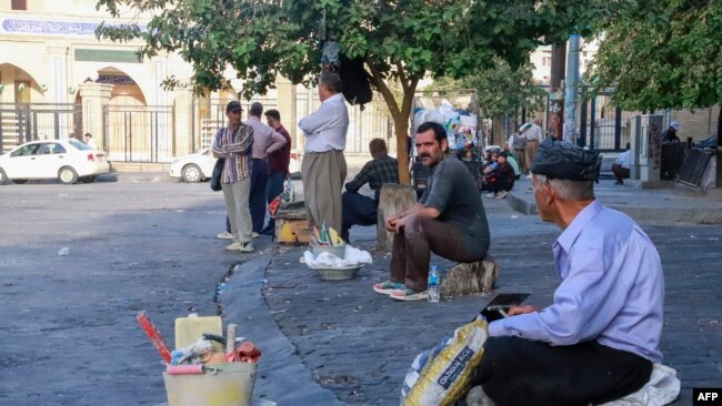 Iranian workers wait for jobs at Workers Square in front of the Great Mosque in central Sulaimaniyah in Iraq's autonomous Kurdistan region, Oct. 5, 2022.