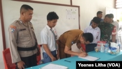 Guru SMA Negeri 2 Poso, Yanto Porayouw menandatangani kesepakatan bersama penyelesaian kasus kekerasan yang ia lakukan terhadap dua siswa di sekolahnya, pada 17 Oktober 2022. (Foto: VOA/Yoanes Litha)