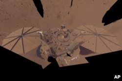 This image provided by NASA shows the InSight Mars lander in a selfie photo composite on April 24, 2022. The lander's solar panels have become covered with dust since the lander touched down on Mars in November 2018, which has led to a gradual decline in its power level. (NASA/JPL-Caltech via AP)