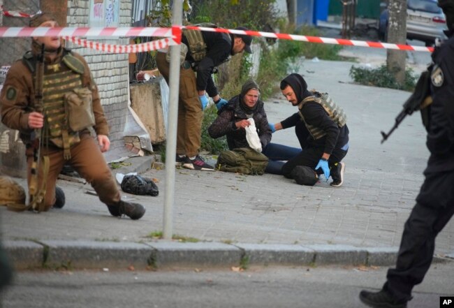 Medics help injured woman after after a drone fired on buildings in Kyiv, Ukraine, Monday, Oct. 17, 2022. (AP Photo/Efrem Lukatsky)