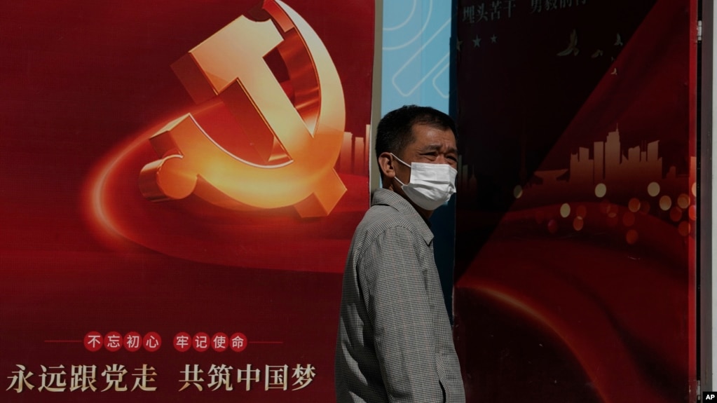 一名男子走过北京街头张贴的中共二十大宣传画。（2022年10月10日）(photo:VOA)
