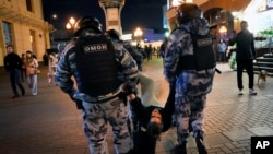 İğtişaş polisi Moskvada səfərbərliyə qarşı keçirilən etirazda nümayişçini saxlayır. 21 sentyabr, 2022. 