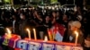 Soccer fans chant slogans during a candle light vigil for Arema FC Supporters who became victims of Saturday's soccer riots, outside the Youth and Sports Ministry in Jakarta, Indonesia, Oct. 2, 2022. Panic and a chaotic run for exits after police fired te