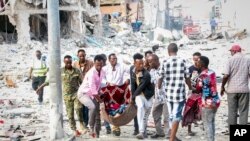 Tim penyelamat mengevakuasi jenazah yang terluka parah dari lokasi serangan bom mobil ganda di Ibu Kota Mogadishu, Somalia, Sabtu, 29 Oktober 2022. (Foto: AP)