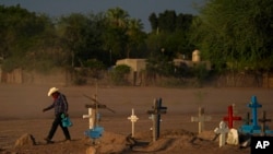 Un indígena yaquí cruza un cementerio donde se encuentra sepultado Tomás Rojo, un activista defensor del agua que fue asesinado, el martes 27 de septiembre de 2022, en Pótam, estado de Sonora, en el noroeste de México. (AP Foto/Fernando Llano)