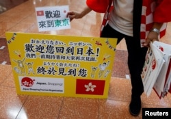 日本一家旅遊公司的員工在羽田機場歡迎一個香港旅遊團。（2022年6月26日）