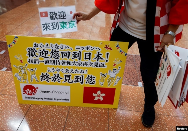 日本一家旅游公司的员工在羽田机场欢迎一个香港旅游团。（2022年6月26日）