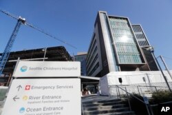 FILE - A sign stands outside Seattle Children's Hospital on March 18, 2020, in Seattle. Children's hospitals in parts of the country are seeing a distressing surge in RSV. (AP Photo/Elaine Thompson, File)